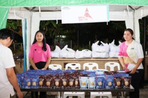 a couple of women standing behind a table with food items Cookies